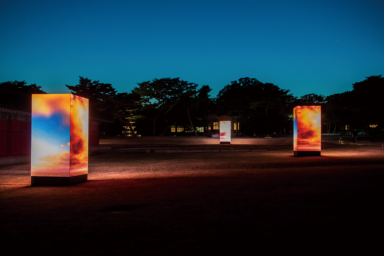 LED 기둥을 통해 상영되는 디지털 작품은 ‘일월오봉도’를 표현한 것이다. 이진준 교수는 AI 딥러닝(AI가 스스로 정보를 학습하듯 다층구조의 인공신경망 방식으로 정보를 처리하는 기술)을 이용해 작품을 만들었다. AI가 자연의 변화를 포착하고 언리얼 엔진(사실적 이미지를 실시간으로 만들어내는 3D 소프트웨어) 등 다양한 현대 미디어 기술 기법을 적용했다.Sun, Moon and Five Mountains : Jinjoon Lee, 2022, 1.5m×1.5m×3m×8box, LED Digital Sculpture and Video Installation in Changgyeonggung.